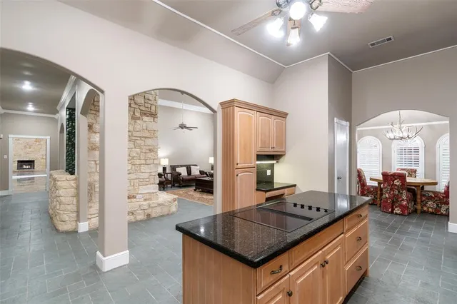 a kitchen with stainless steel appliances granite countertop a stove and a view of living room
