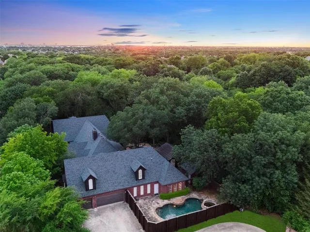 an aerial view of residential houses with outdoor space and trees