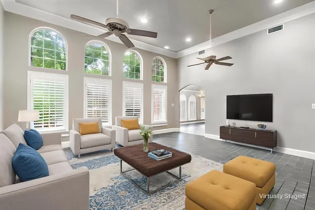 a living room with furniture a flat screen tv and a large window