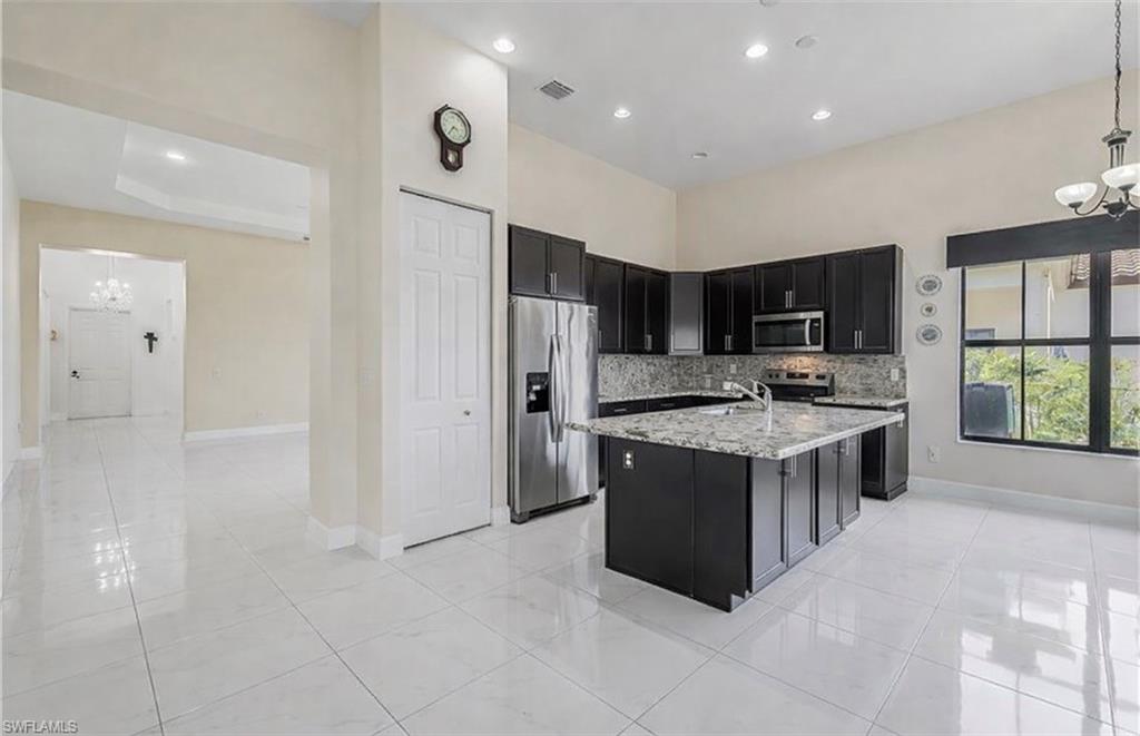 4761 Rosetta Terrace Ave Maria, FL 34142 - Photo 7 of 35 a kitchen with stainless steel appliances granite countertop a stove and a refrigerator