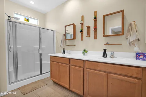 a bathroom with a double vanity sink mirror and shower