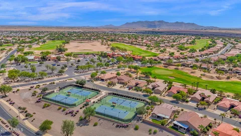 an aerial view of a city with lots of residential buildings ocean and mountain view in back