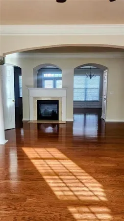 a view of empty room with wooden floor and fireplace