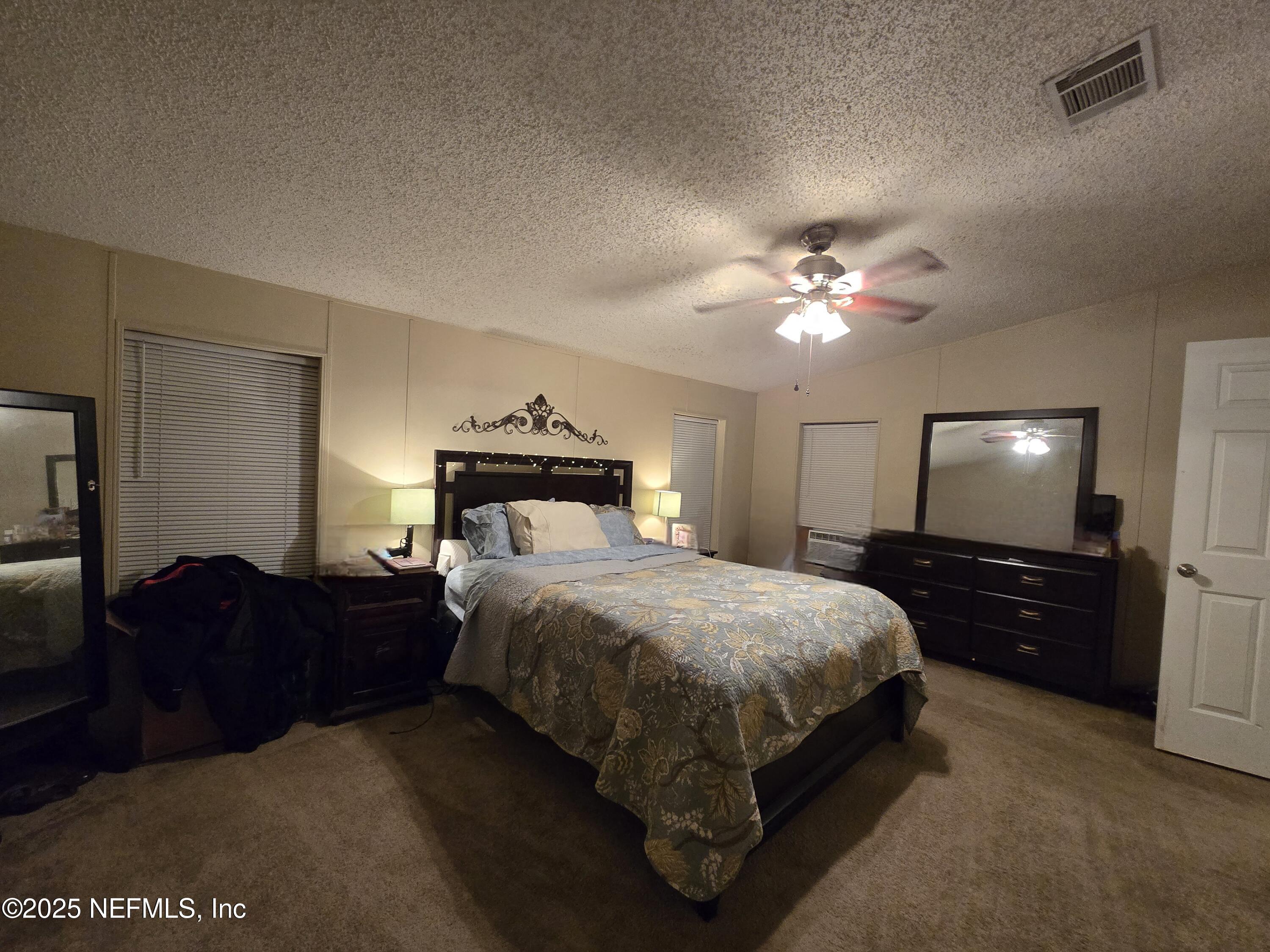 85050 Myrtice Road Yulee, FL 32097 - Photo 19 of 87 a bedroom with a bed and a chandelier