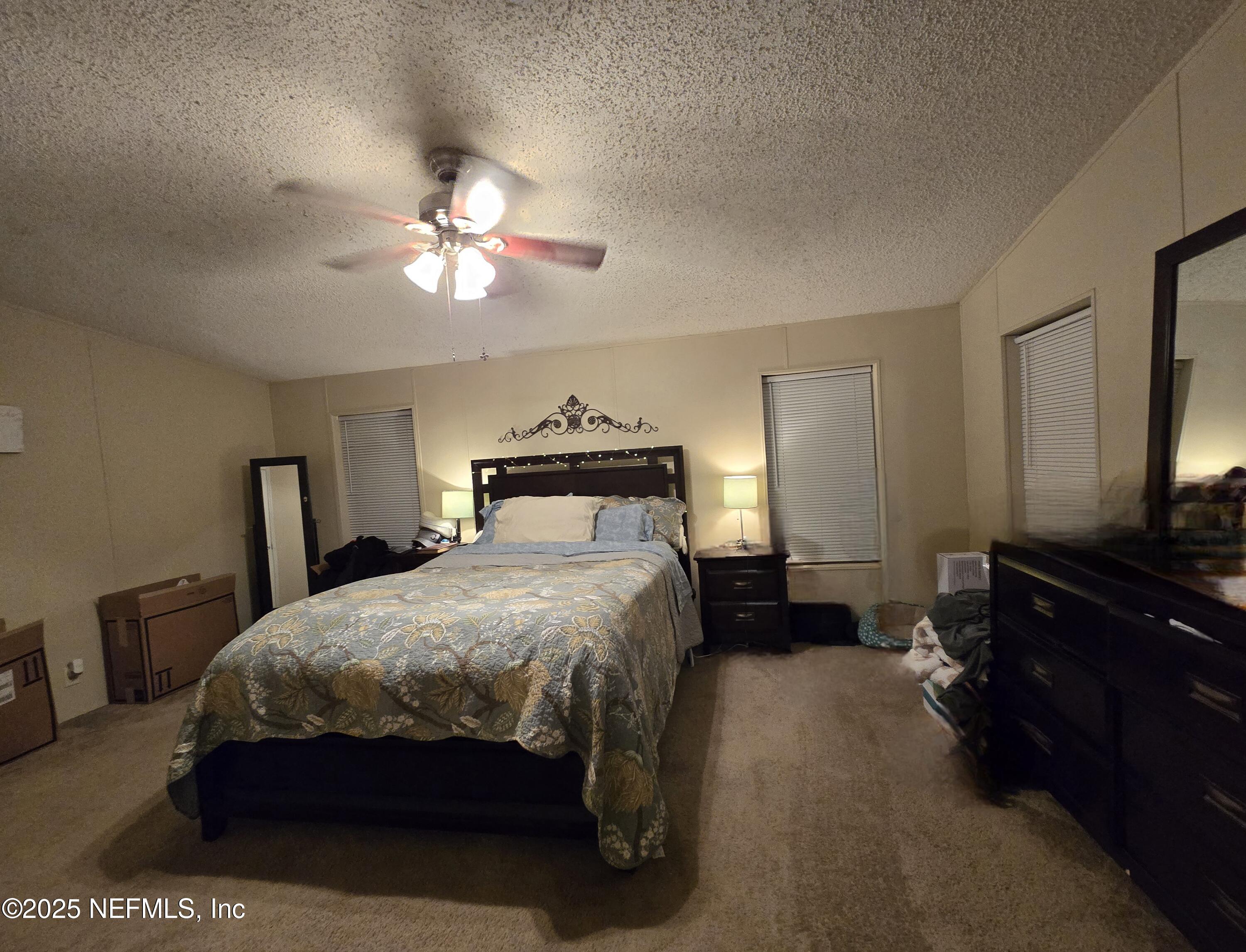 85050 Myrtice Road Yulee, FL 32097 - Photo 23 of 87 a bedroom with a bed and a chandelier