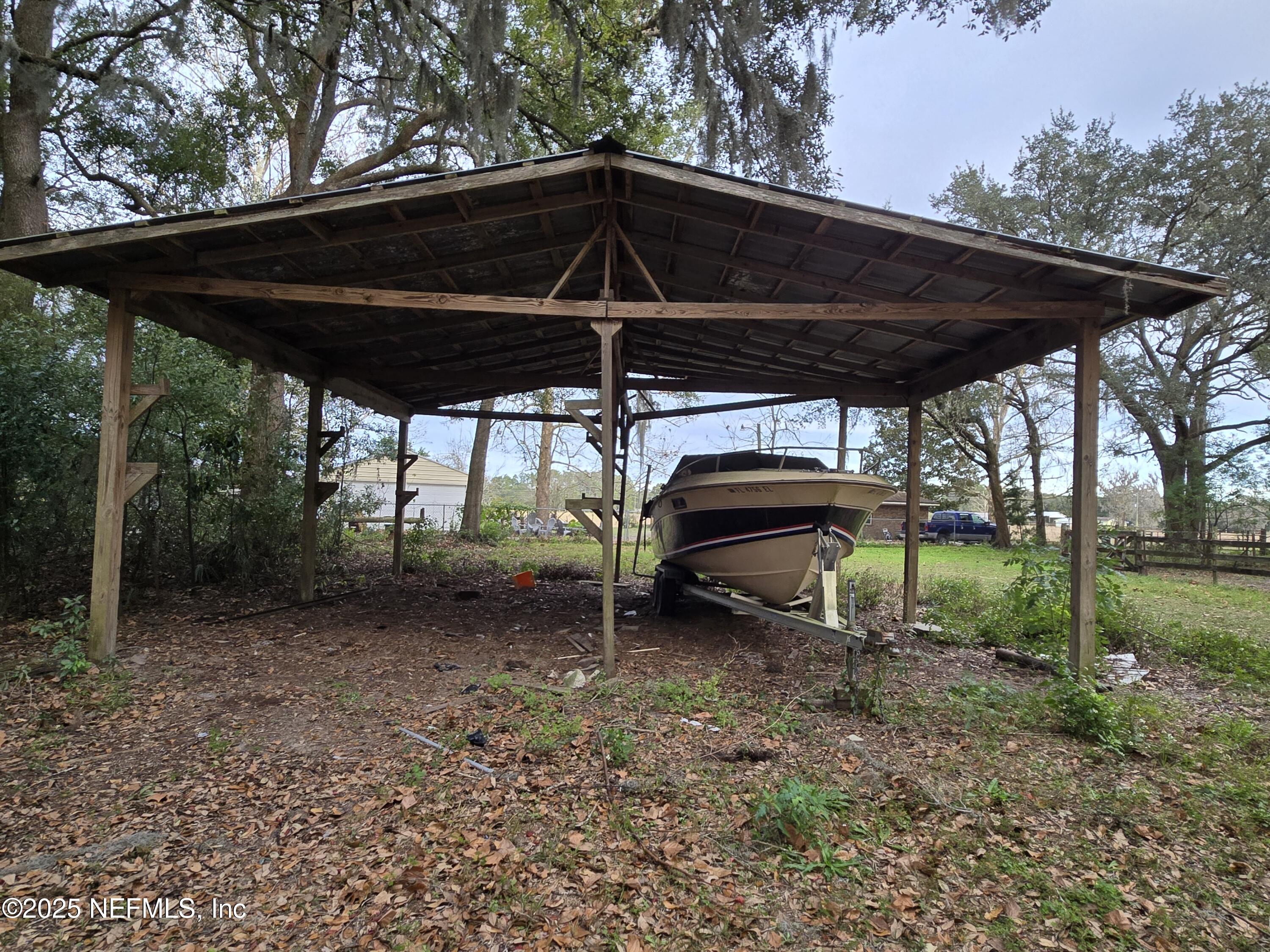 85050 Myrtice Road Yulee, FL 32097 - Photo 56 of 87 a view of a backyard with table and chairs under an umbrella