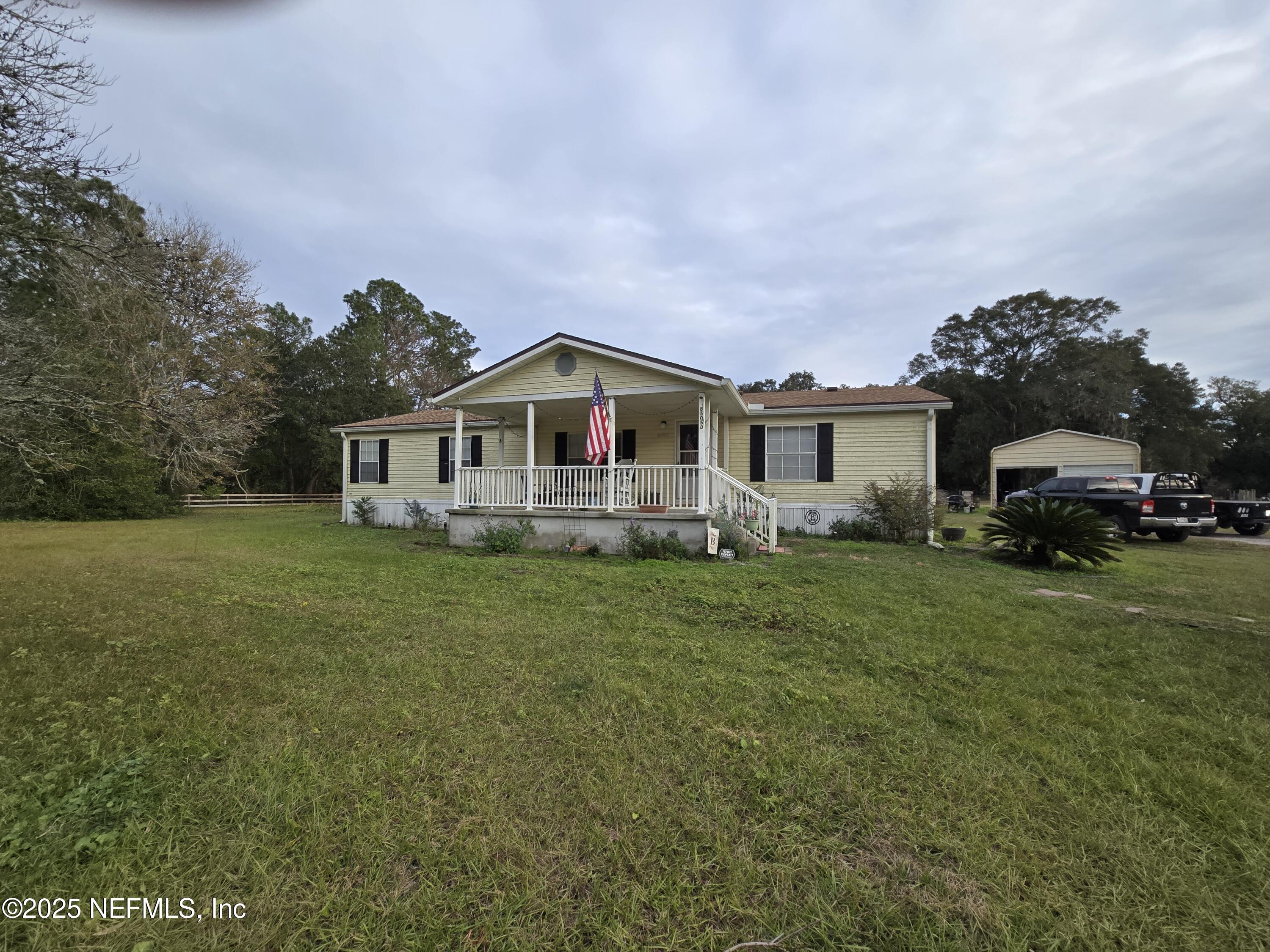 85050 Myrtice Road Yulee, FL 32097 - Photo 9 of 87 a front view of a house with a garden and trees