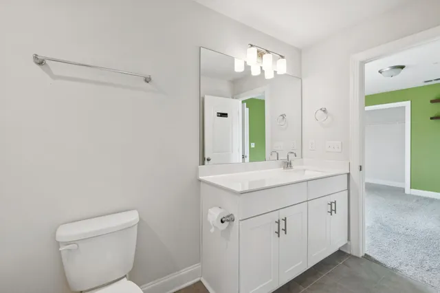 a bathroom with a granite countertop sink a toilet and a mirror