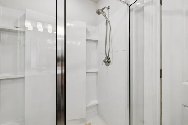 a bathroom with a glass shower door and a glass door