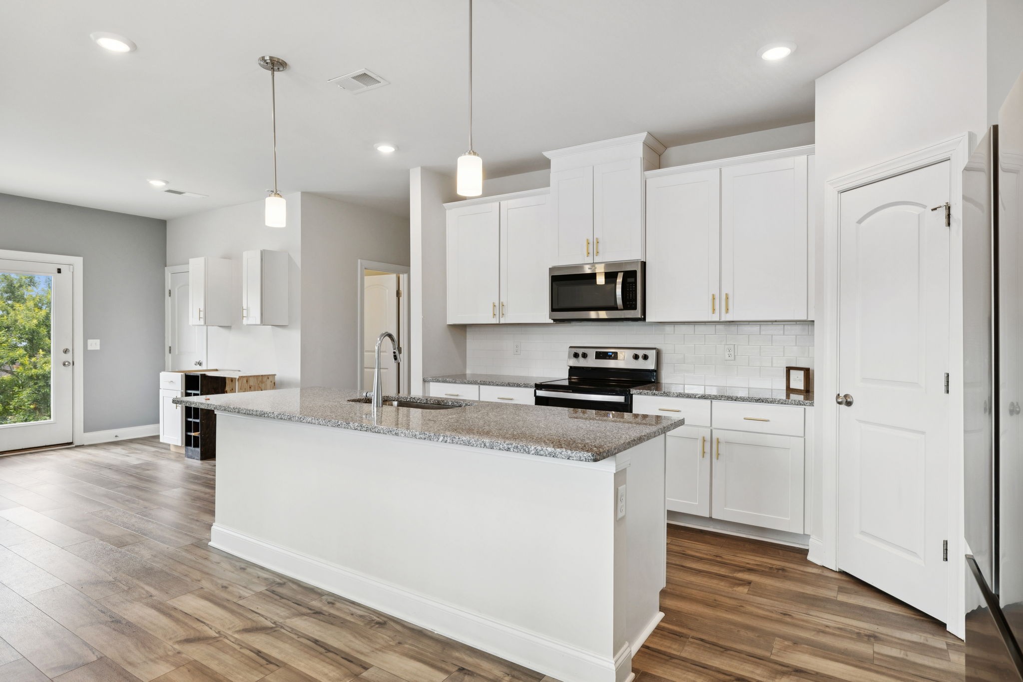 862 Longleaf Lane Columbia, TN 38401 - Photo 32 of 35 a kitchen with stainless steel appliances a stove a refrigerator a sink and white cabinets with wooden floor