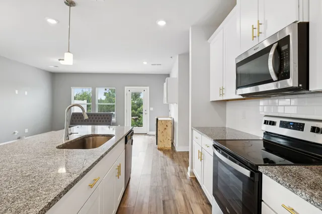 a kitchen with a sink a stove and cabinets