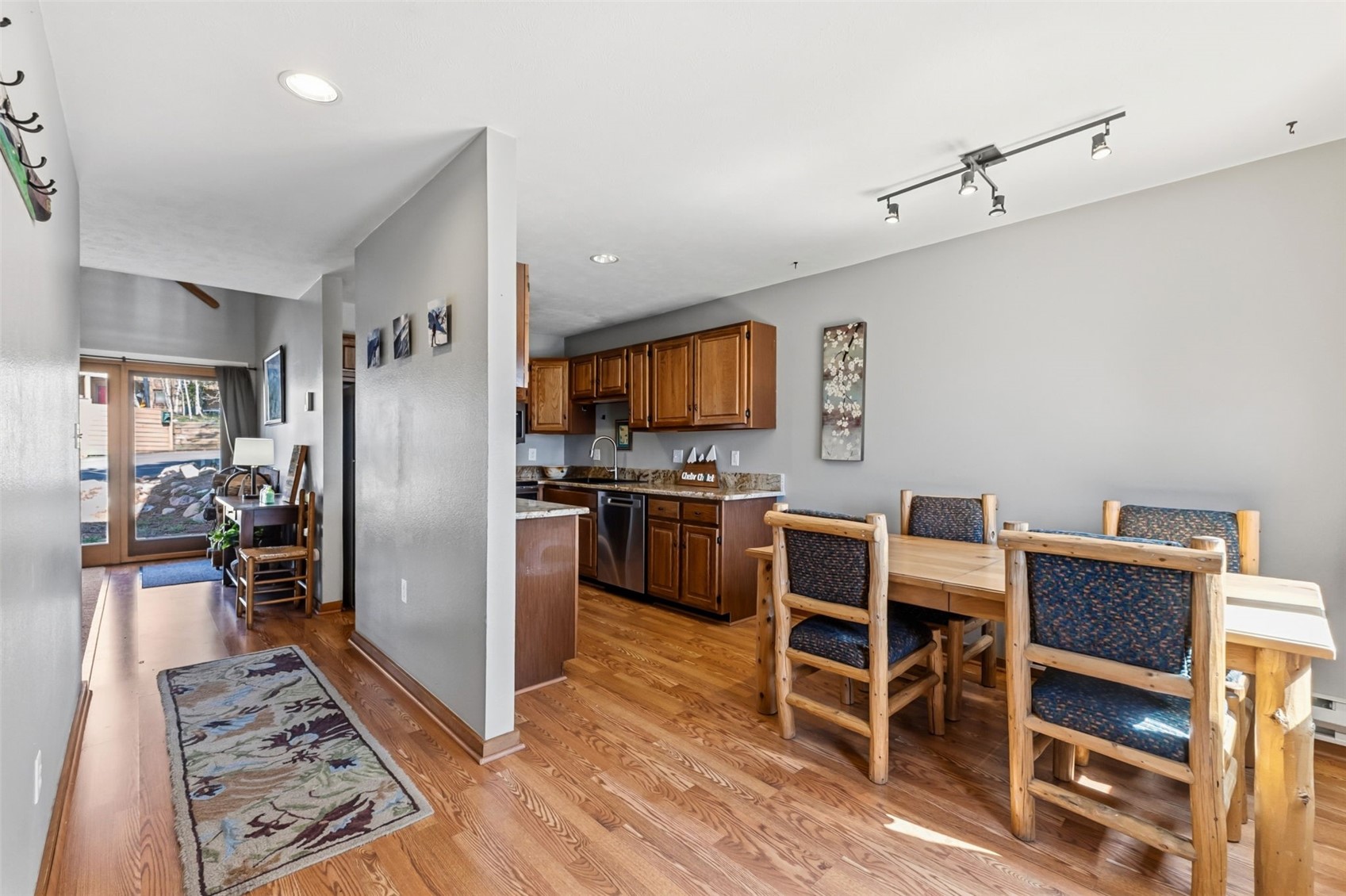 6734 Ryan Gulch Road, Unit 6734 Silverthorne, CO 80498 - Photo 12 of 33 a kitchen with stainless steel appliances wooden floor and chairs