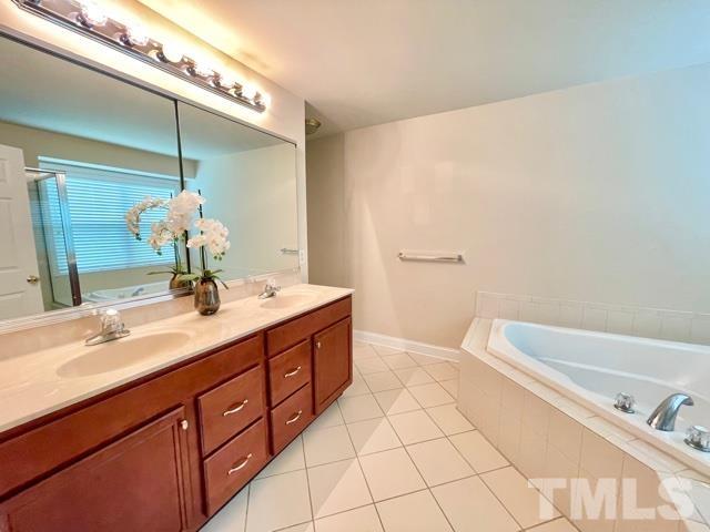 11239 11239th Raleigh, NC 27617 - Photo 14 of 26 a bathroom with a double vanity sink and a bathtub