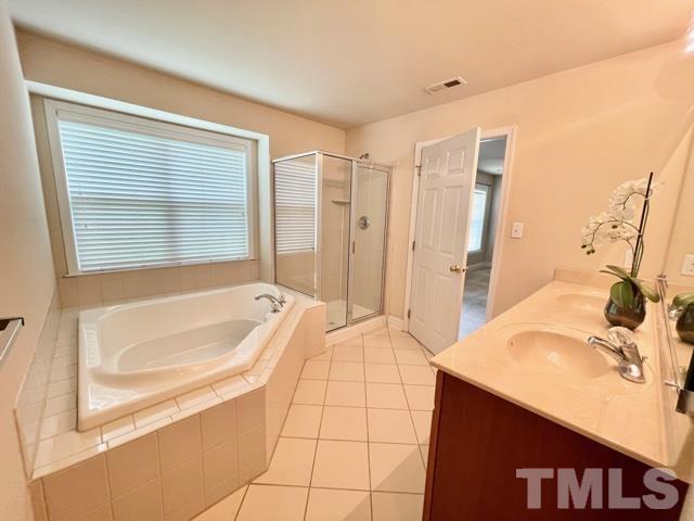 11239 11239th Raleigh, NC 27617 - Photo 15 of 26 a bathroom with a tub a sink a mirror and a shower
