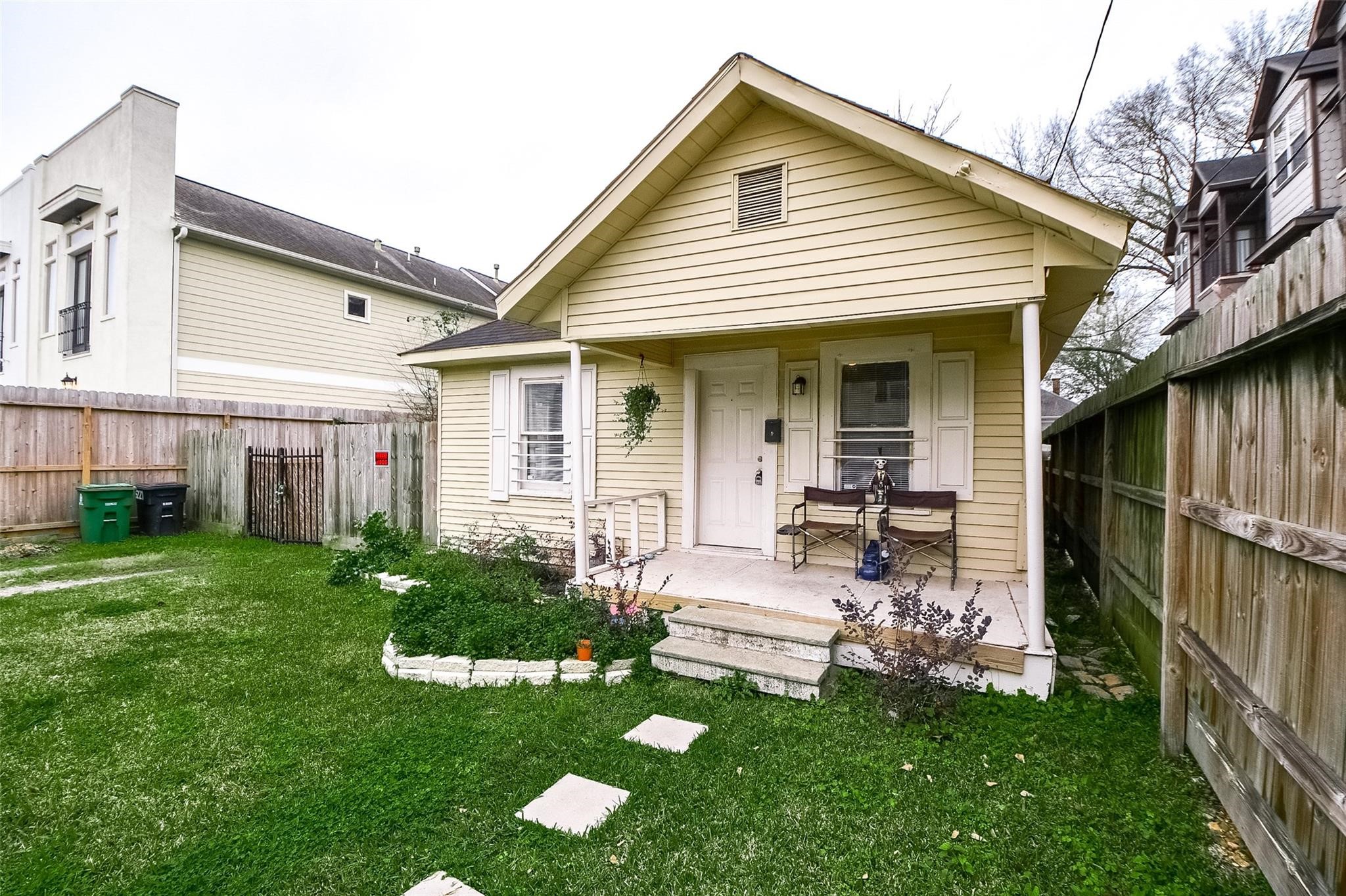 a view of a chair and table in backyard of the house
