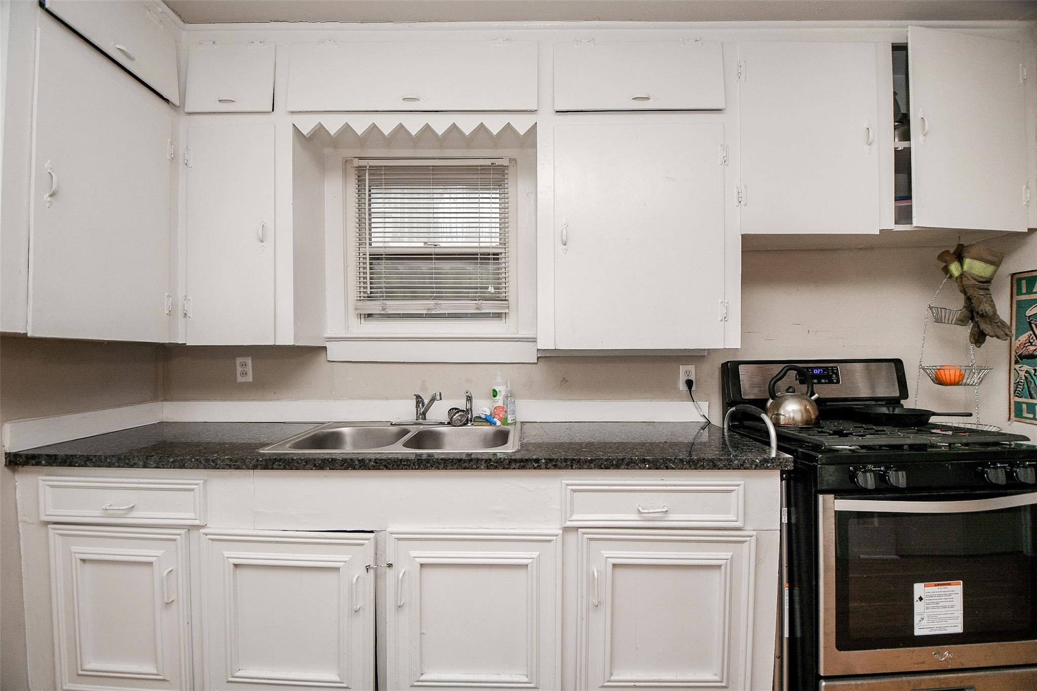 5221 Darling Street Houston, TX 77007 - Photo 12 of 22 a kitchen with granite countertop a sink a stove and cabinets