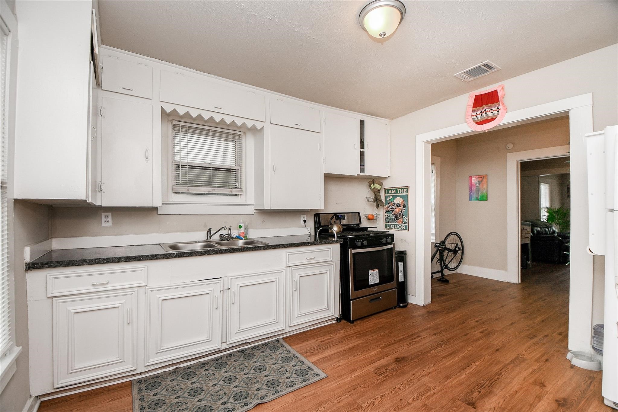 5221 Darling Street Houston, TX 77007 - Photo 4 of 22 a kitchen with granite countertop a sink cabinets and stainless steel appliances
