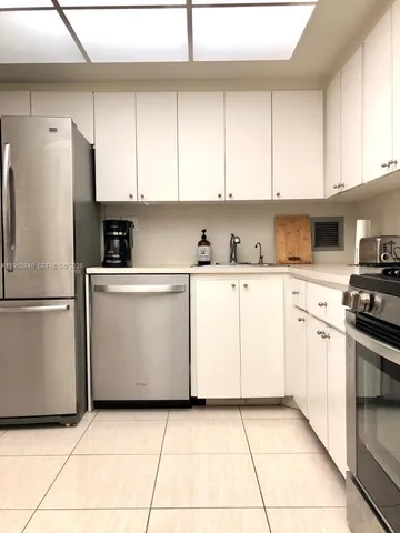 a kitchen with white cabinets and white appliances