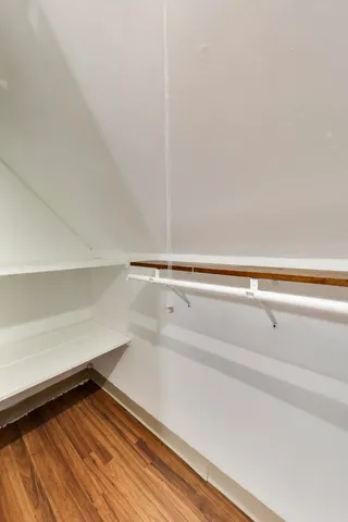 a view of a closet with wooden floor