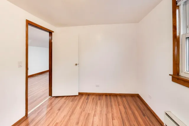 a view of a small space with wooden floor and a window