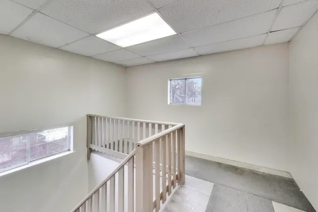 a view of staircase with railing and white walls