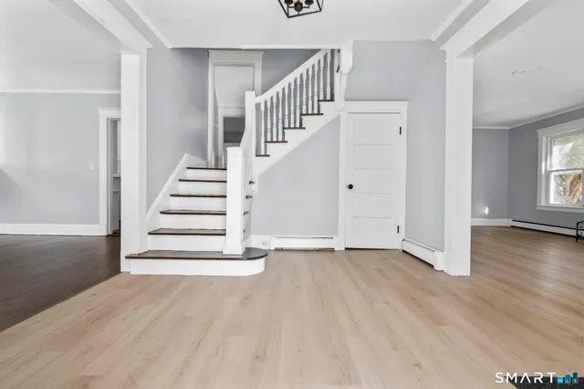 a view of entryway and hall with wooden floor