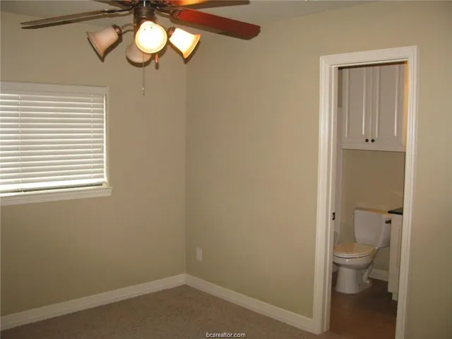 a bathroom with a toilet and a window