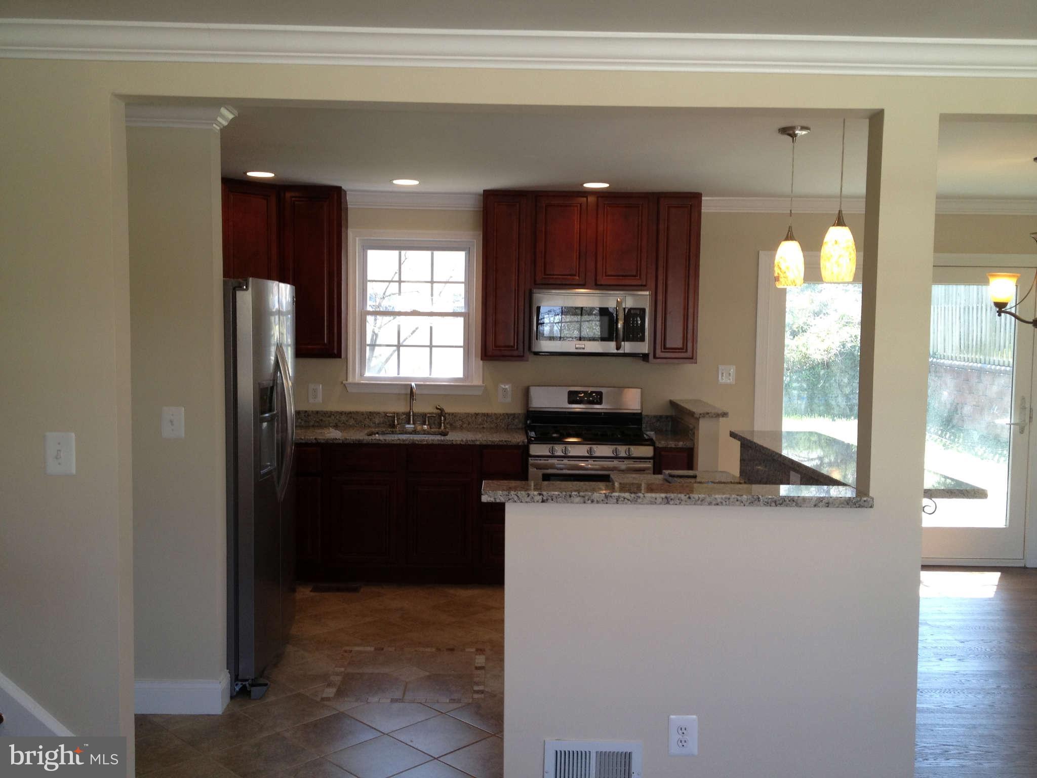 203 Mansion Road Linthicum, MD 21090 - Photo 3 of 28 a kitchen with stainless steel appliances granite countertop a refrigerator a stove a sink and a microwave