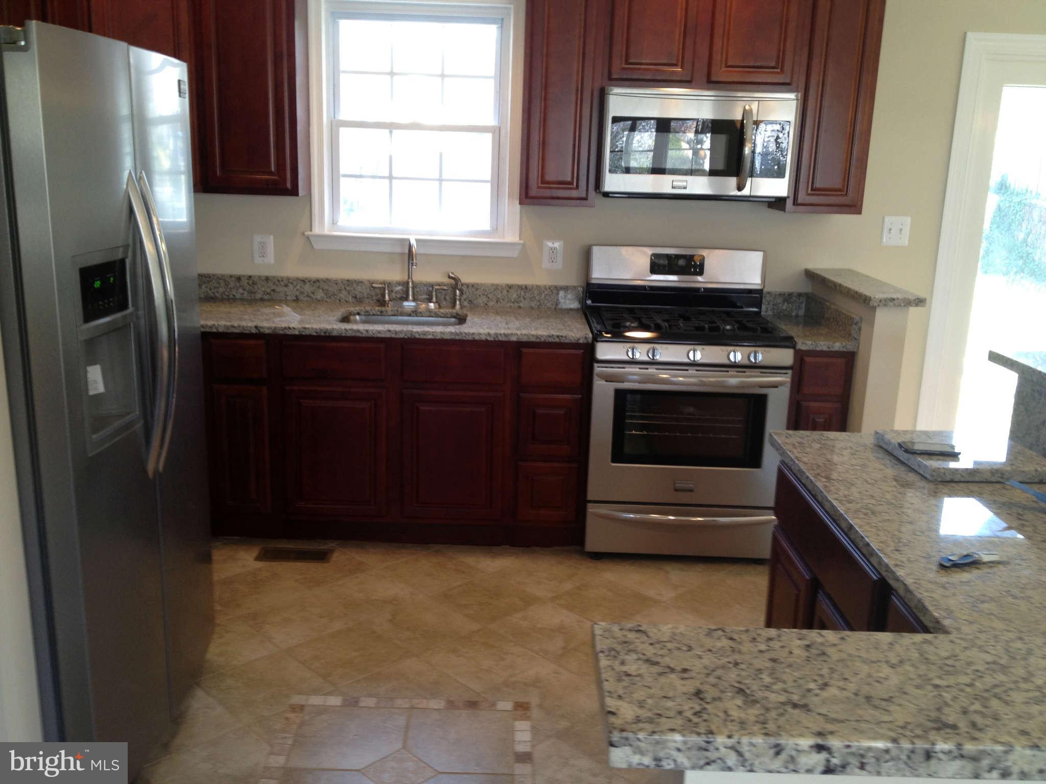 203 Mansion Road Linthicum, MD 21090 - Photo 8 of 28 a kitchen with stainless steel appliances granite countertop a stove a refrigerator and a sink