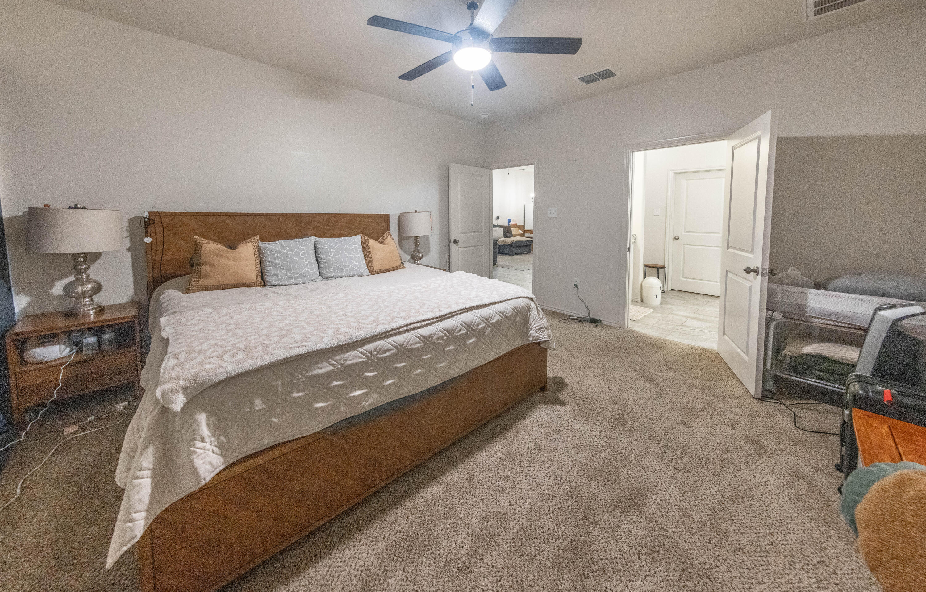 5510 Lehigh Street Lubbock, TX 79416 - Photo 11 of 32 a spacious bedroom with a bed and a chandelier