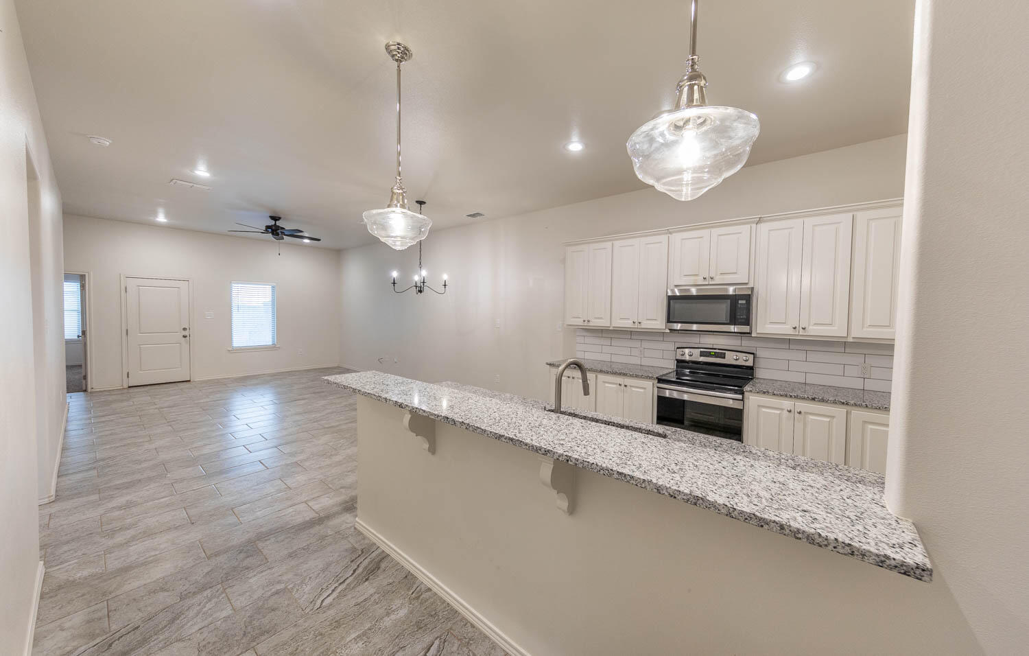5510 Lehigh Street Lubbock, TX 79416 - Photo 17 of 32 a kitchen with stainless steel appliances a large counter top space cabinets and wooden floor