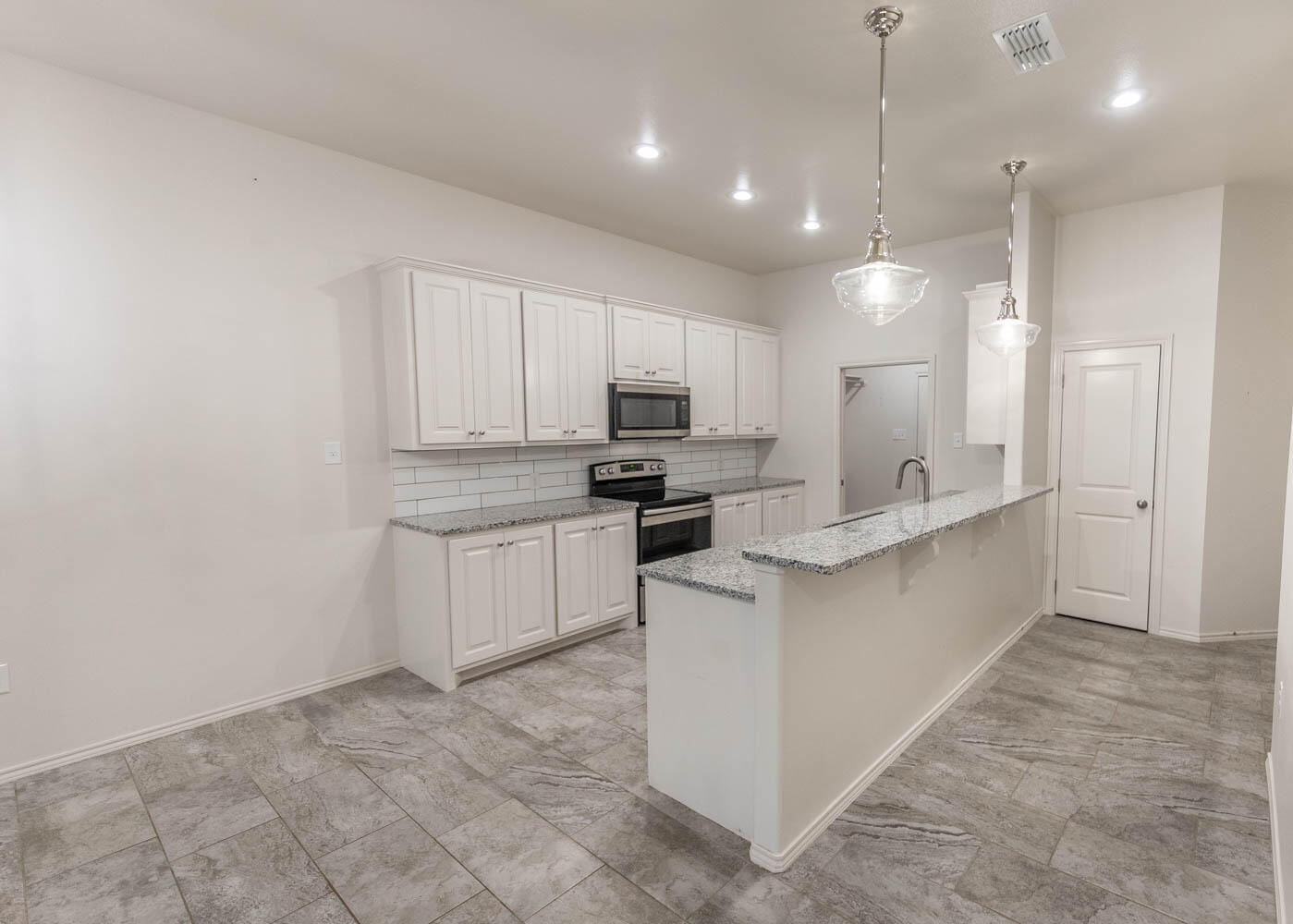 5510 Lehigh Street Lubbock, TX 79416 - Photo 21 of 32 a large kitchen with cabinets and stainless steel appliances