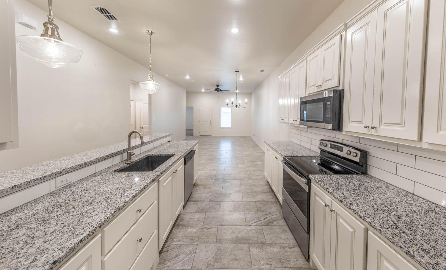 5510 Lehigh Street Lubbock, TX 79416 - Photo 23 of 32 a large kitchen with stainless steel appliances granite countertop a sink stove and cabinets