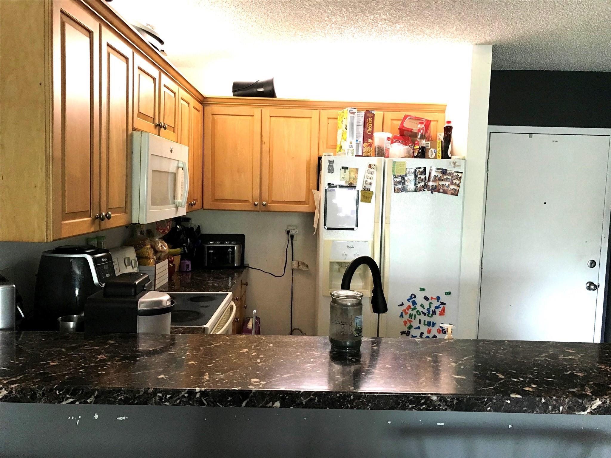 2501 Riverside Drive, Unit 417A Coral Springs, FL 33065 - Photo 1 of 8 a kitchen with sink a refrigerator and a stove