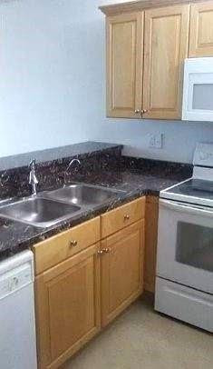2501 Riverside Drive, Unit 417A Coral Springs, FL 33065 - Photo 4 of 8 a kitchen with granite countertop white cabinets and sink
