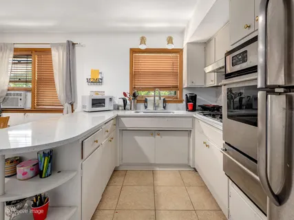 a kitchen with stainless steel appliances a sink window and cabinets