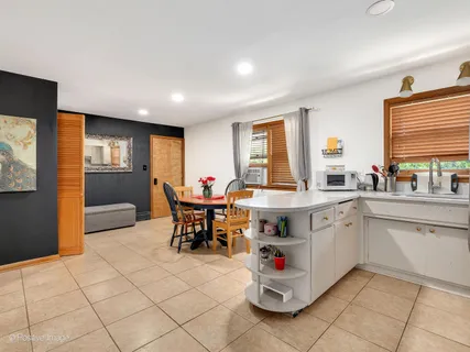 a kitchen with a sink dining table and chairs