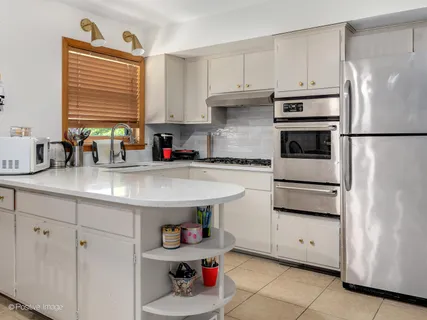 a kitchen with stainless steel appliances a refrigerator sink and cabinets