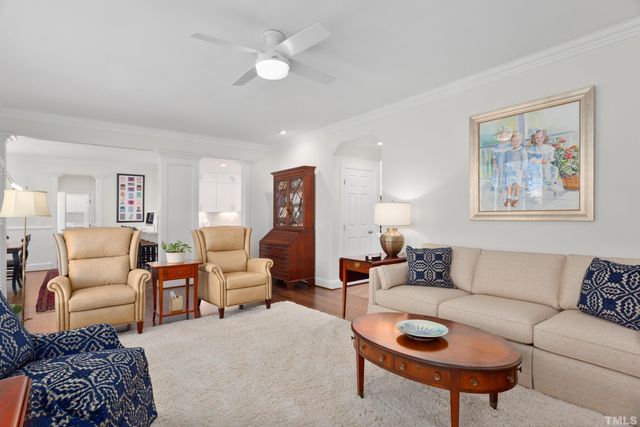 a living room with furniture a couch and paintings on the wall