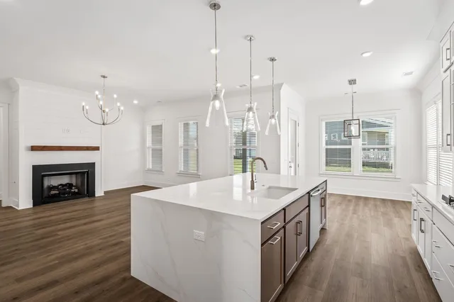 a kitchen with stainless steel appliances a sink a stove a refrigerator and white cabinets