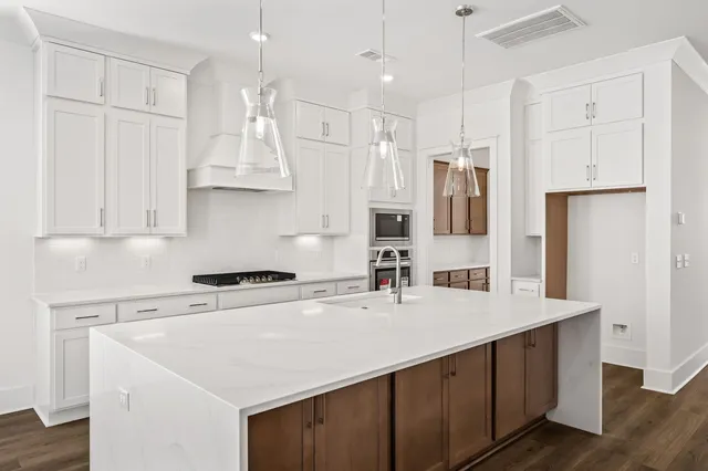 an empty room with wooden floor closet and windows