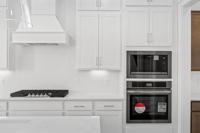 a kitchen with stainless steel appliances granite countertop a sink a stove and a refrigerator