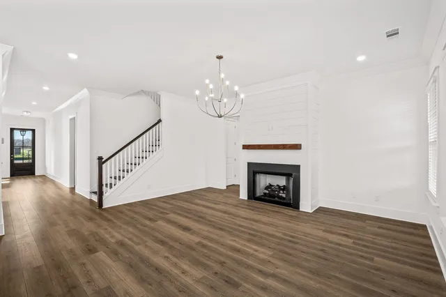 a view of empty room with wooden floor and fireplace
