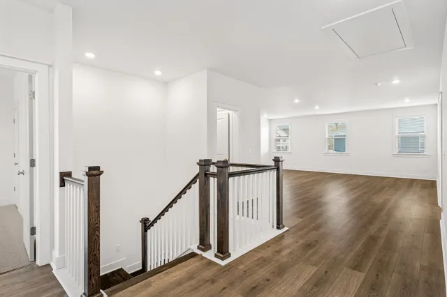 a view of an empty room with wooden floor and closet