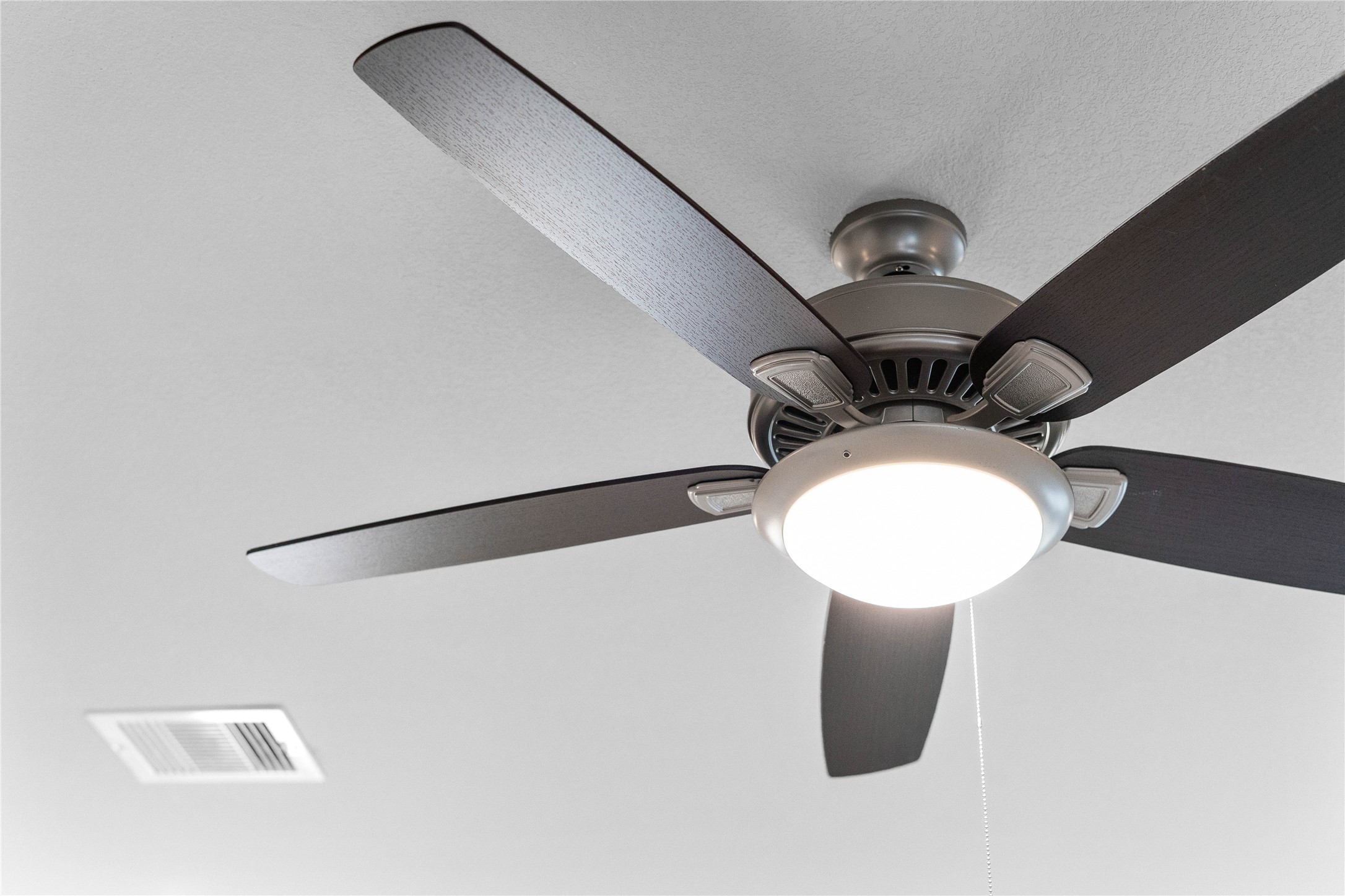 19555 Montgomery Rdg Way Montgomery, TX 77316 - Photo 24 of 38 This contemporary ceiling fan features a brushed nickel finish and five dark wood blades, centered by an integrated LED light kit and a traditional pull chain for effortless control. The ceiling fan will make a room feel up to 4–8 degrees cooler and redistribute rising warm air in the winter.