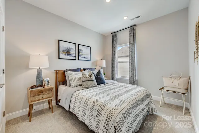a bedroom with a large bed and a painting on the wall