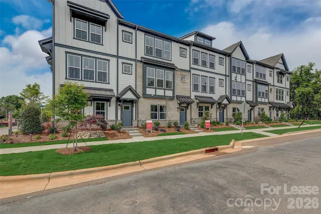 a front view of residential building with street view and trees