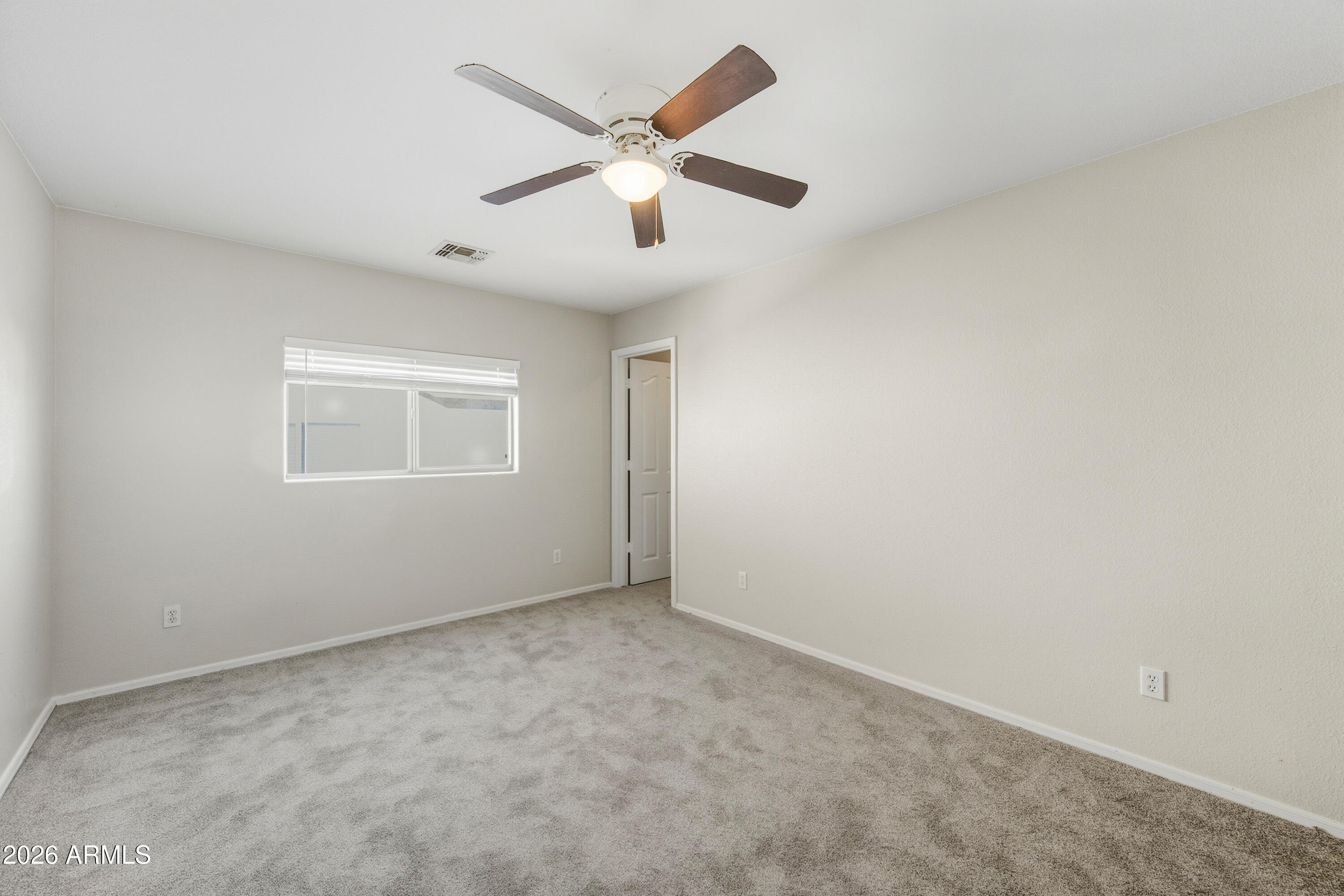 45651 West Barbara Lane Maricopa, AZ 85139 - Photo 17 of 32 an empty room with ceiling fan and window
