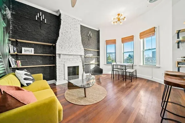a living room with furniture a fireplace and wooden floor