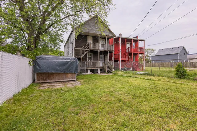 a front view of house with yard and trees in the background